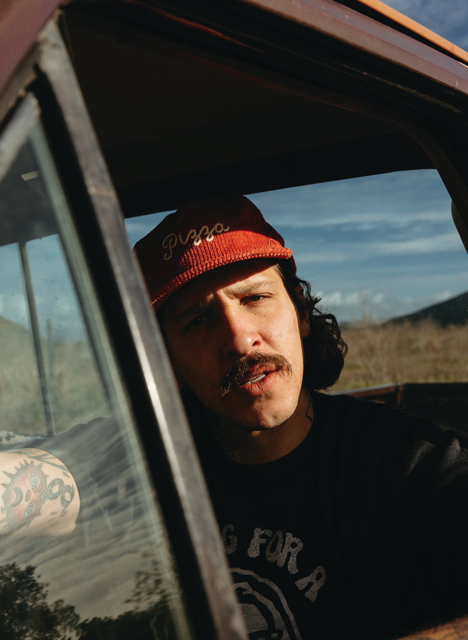Man Model in Pizza Chainstitch Hat with red corduroy in a vintage truck.