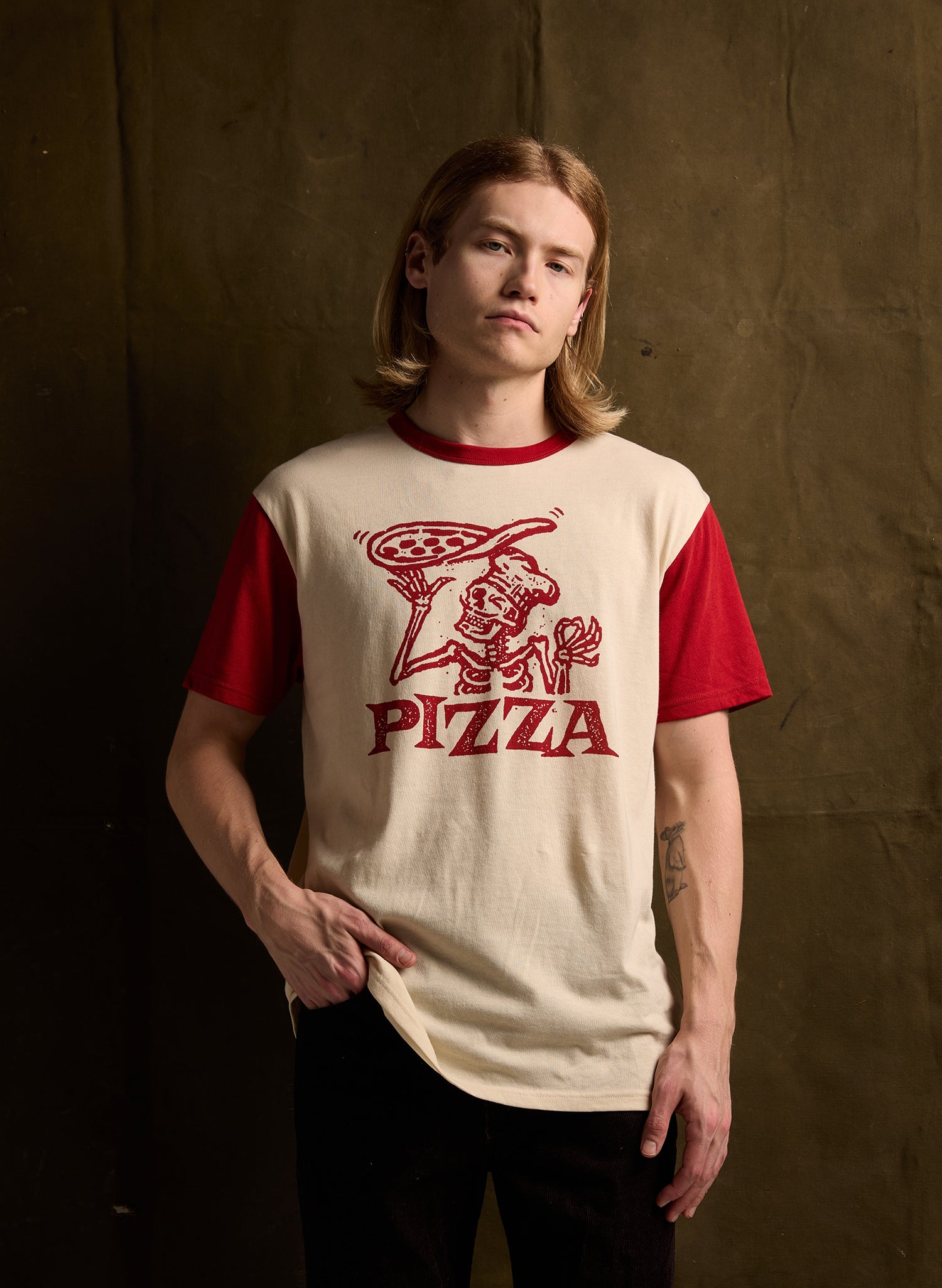 Skeleton chef Pizza Tee in Cream with Marinara Red collar and sleeves, showcasing retro pizza box-inspired screenprint on soft cotton-rayon blend.